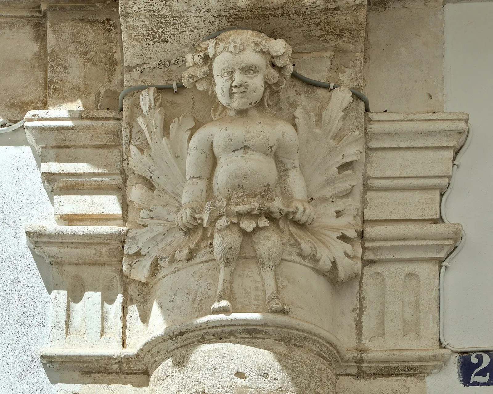 Mensola barocca scolpita con un putto sulla facciata di Palazzo Magli, a Martina Franca