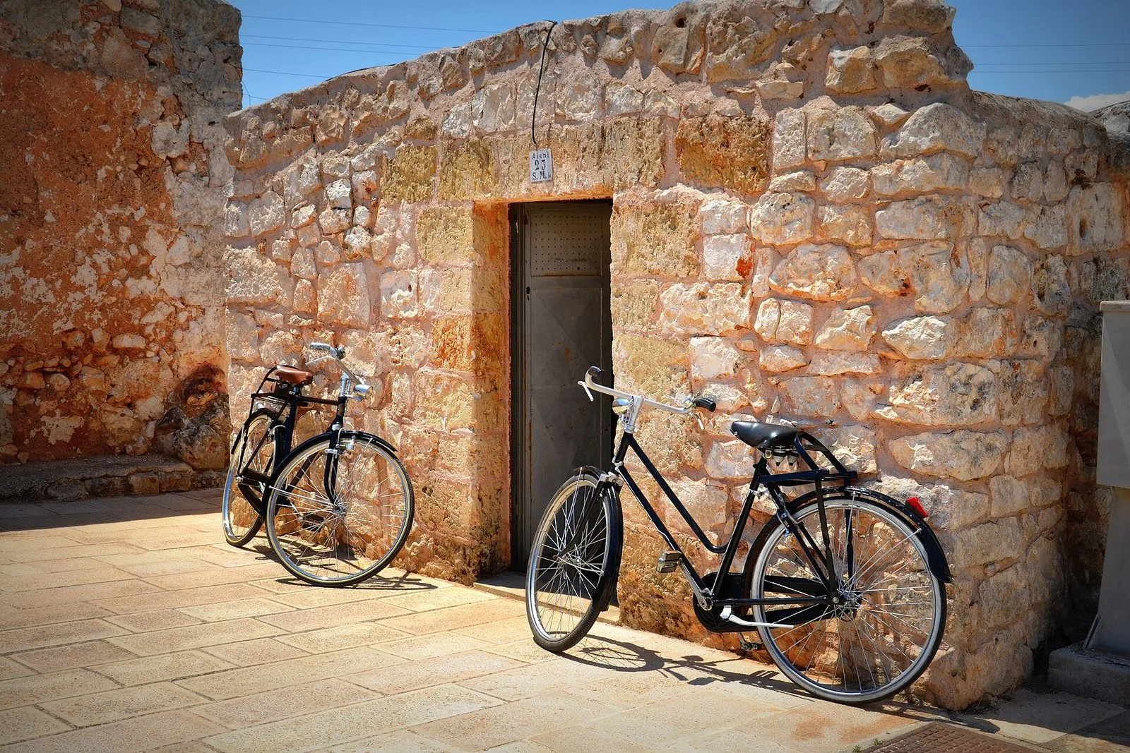 Un muretto a secco in pietra nella campagna pugliese, con due biciclette appoggiate
